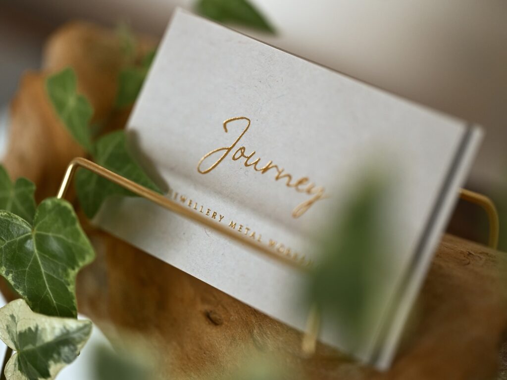 White Journey shop card featuring a gold foil logo