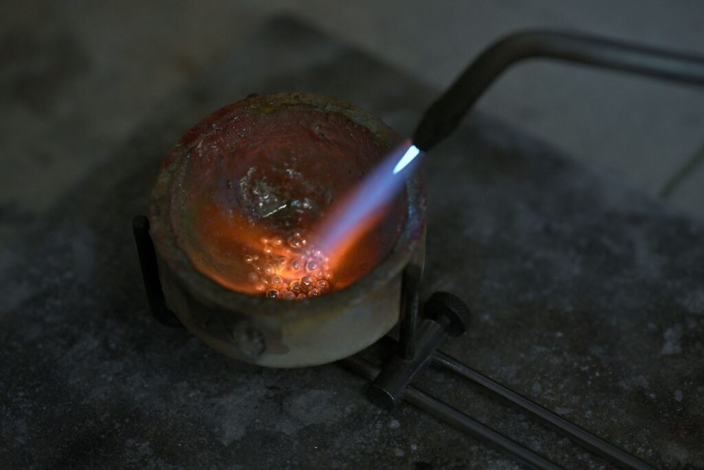 Precious metal being melted for bespoke jewellery and wedding band production