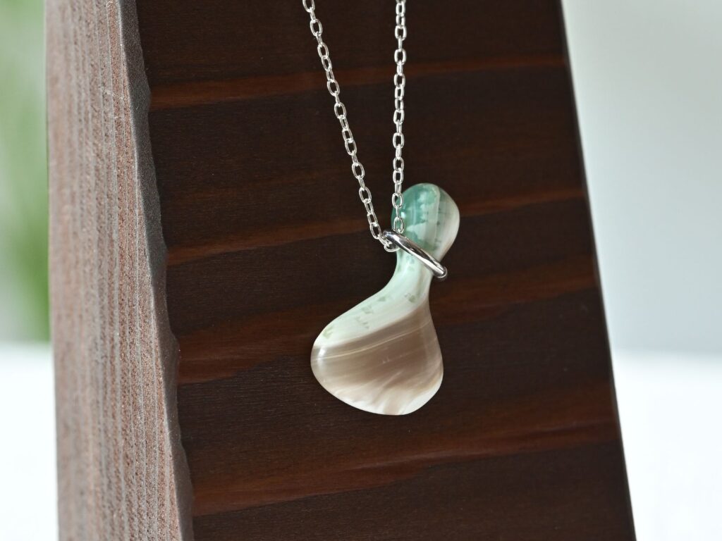 Memory of the Okinawan Sea pendant featuring an organically shaped green turbo shell