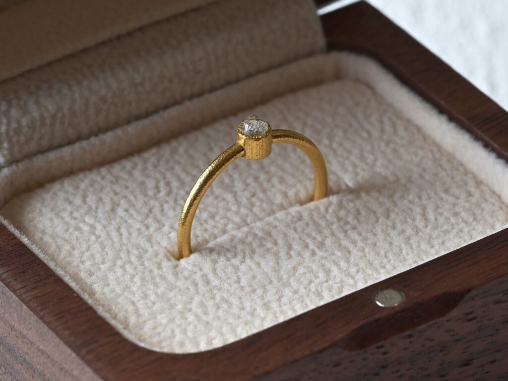 Primitive ring featuring a white rough diamond set in 18K yellow gold