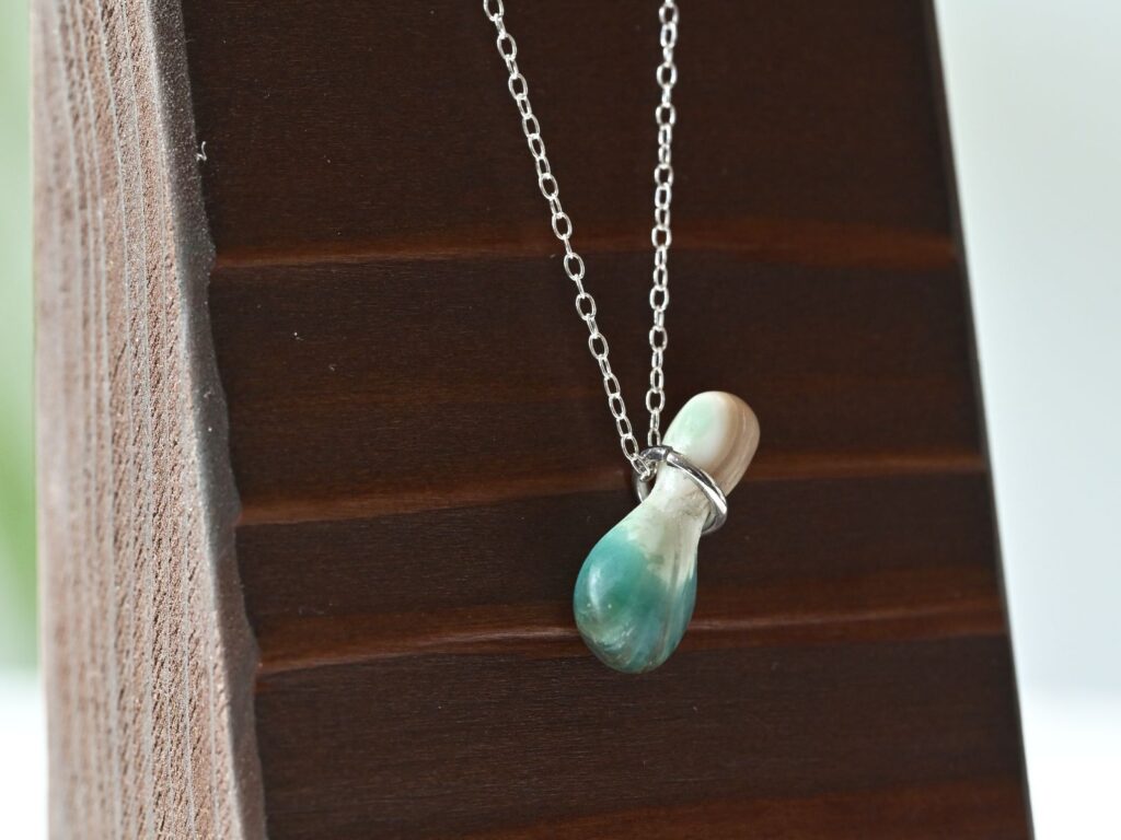 Memory of the Okinawan Sea pendant featuring a teardrop-shaped green turbo shell