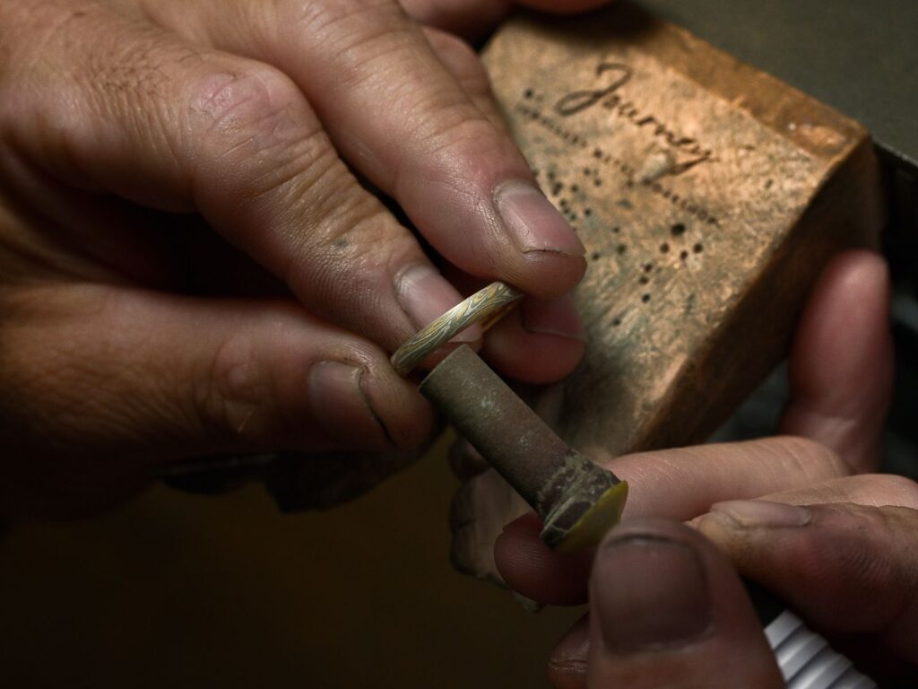 Hand-finishing a custom Mokumegane wedding band in the jewellery-making process