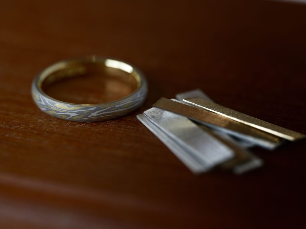 Mokumegane wedding band with the precious metal materials used to create its unique woodgrain pattern