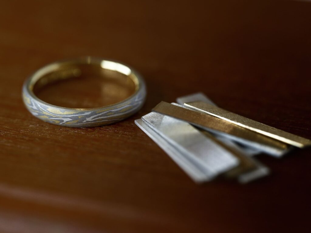 木目金（杢目金）の結婚指輪と、制作に用いる複数の金属素材
