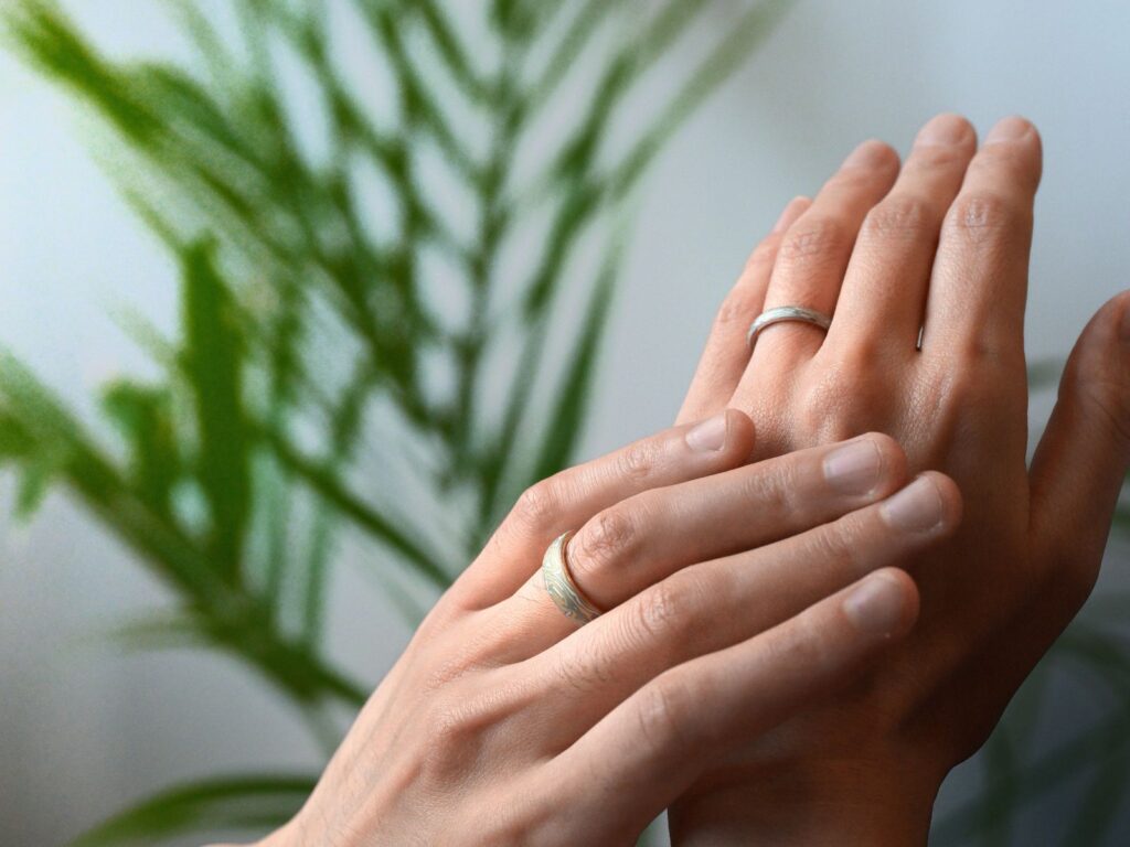 A couple wearing custom Mokumegane wedding bands on their hands