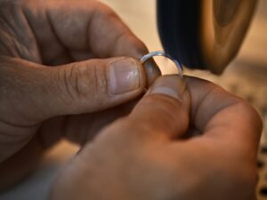 Craftsperson refinishing a wedding band during maintenance