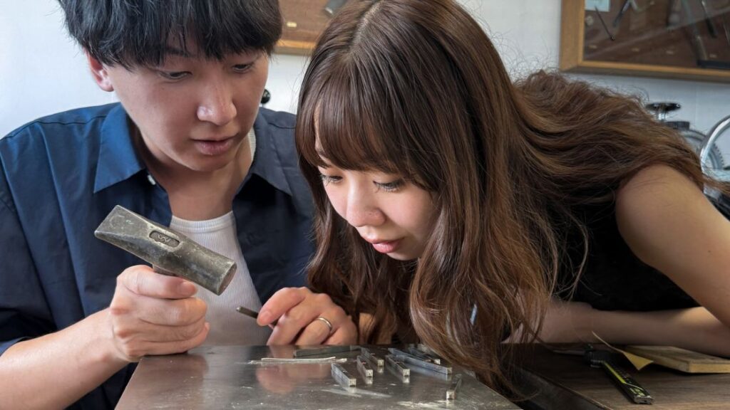 Couple stamping a wedding band during the Wedding Band Workshop