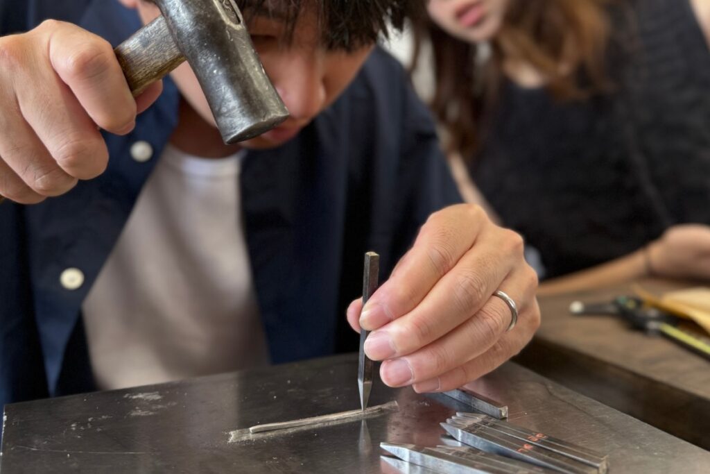 沖縄のJourneyで結婚指輪を手作りするHand Stamping Course。金槌と刻印工具を使って指輪に模様を刻む参加者