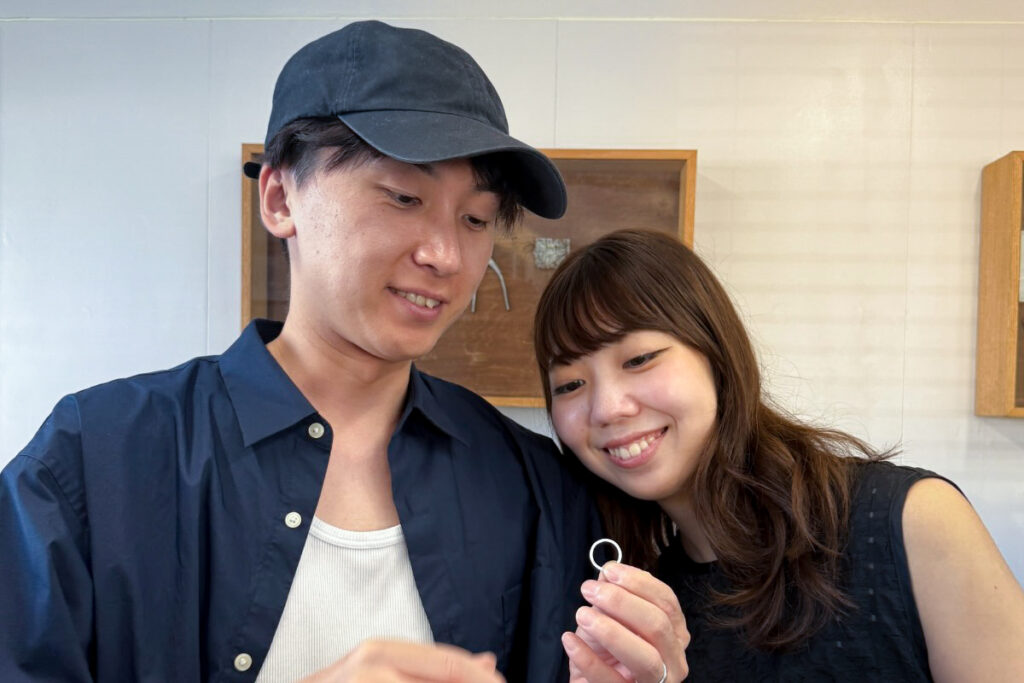 沖縄のJourneyで結婚指輪を手作りするワークショップ。完成した指輪を手に笑顔を見せるカップル